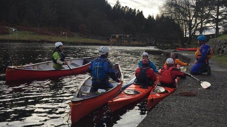 Foundation Safety and Rescue Training. A group in different crafts on the water whilst a tutor gives information from the bank.